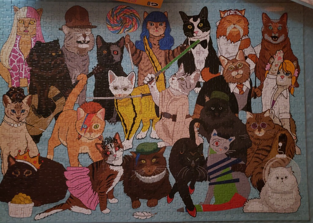 An illustration featuring a large group of cats dressed as various famous pop culture icons and characters.