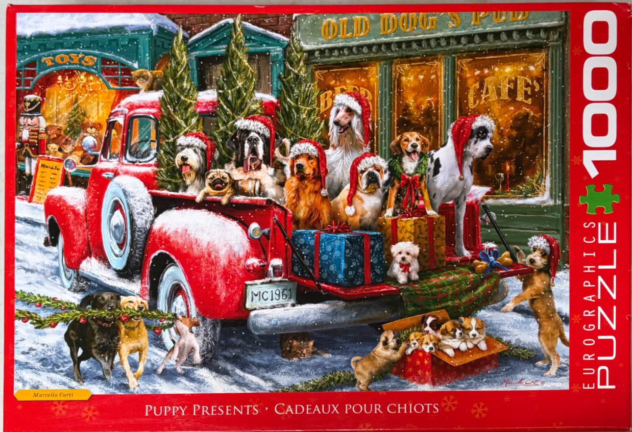 A red vintage pickup truck filled with various breeds of dogs wearing Santa hats in front of a village storefront.