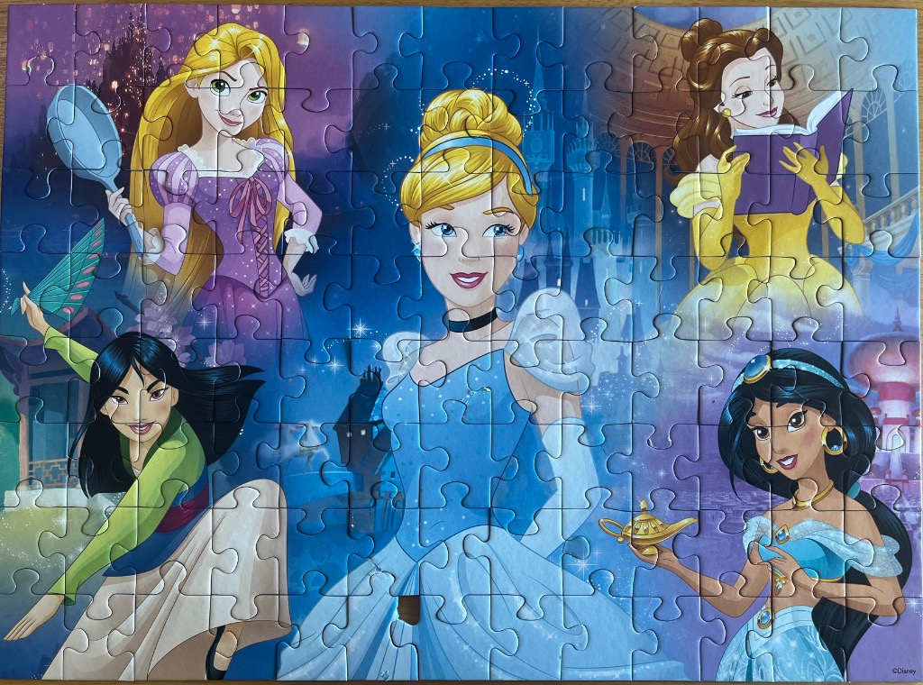 Five Disney princesses arranged in a collage against a blue fantasy background.