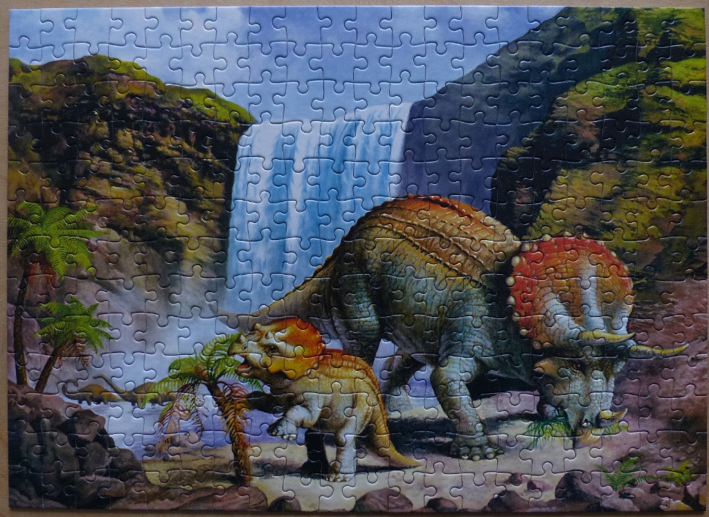 Two Triceratops dinosaurs in a lush, prehistoric valley with a waterfall in the background.