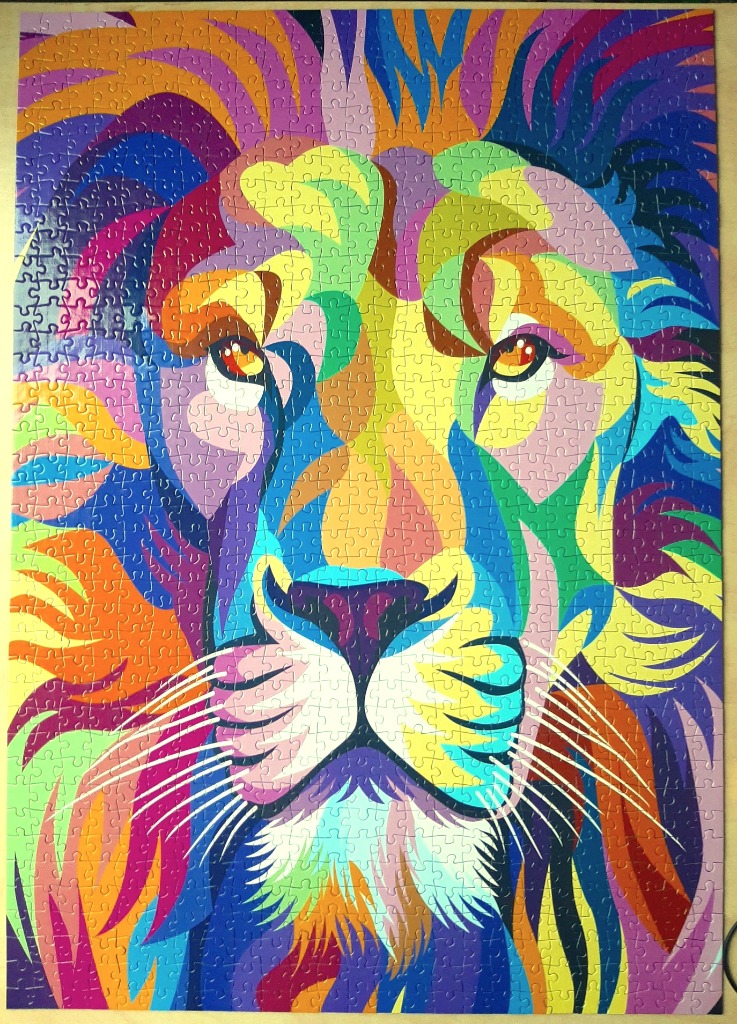 A vibrant pop-art style illustration of a lion's face featuring geometric patterns and a rainbow color palette.