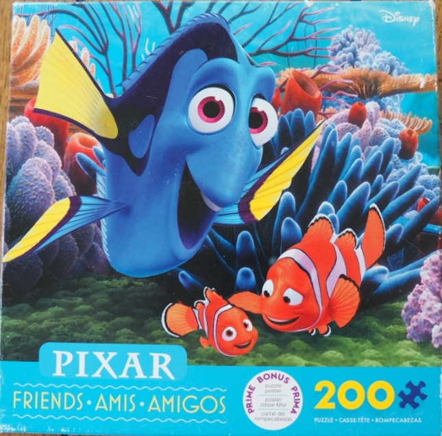 Dory and two clownfish swimming in a vibrant coral reef.