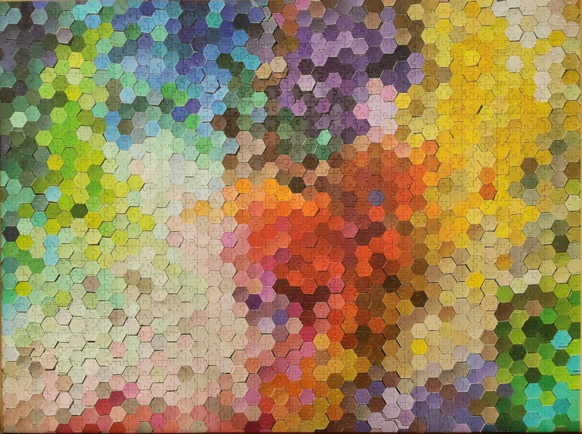 An abstract pattern of interlocking hexagons in a gradient of vibrant, rainbow-like colours.