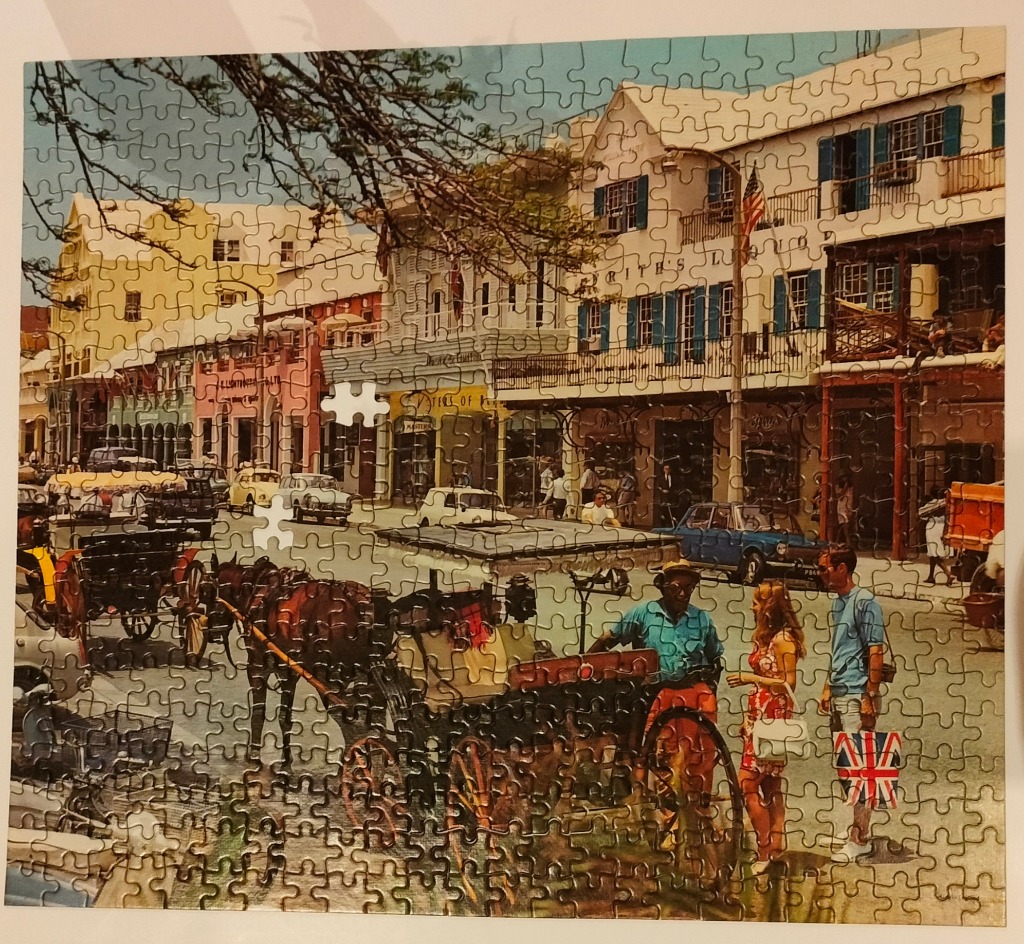 A vintage street scene in Bermuda featuring colonial-style buildings, a horse-drawn carriage, and tourists.