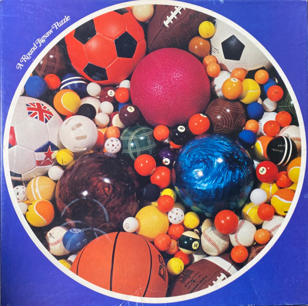 A collection of various sports balls densely packed together in a circular frame.