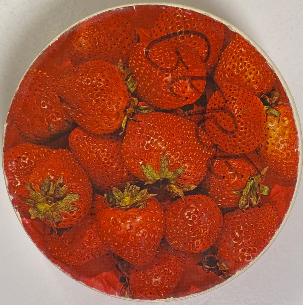 A top-down circular close-up of a pile of ripe, red strawberries.