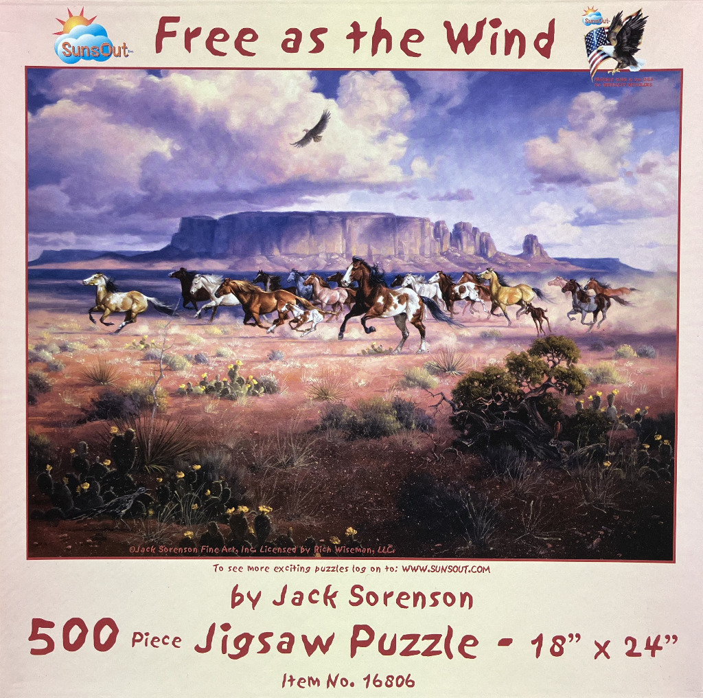 A herd of horses running across a desert landscape beneath a large mesa and a cloudy sky.