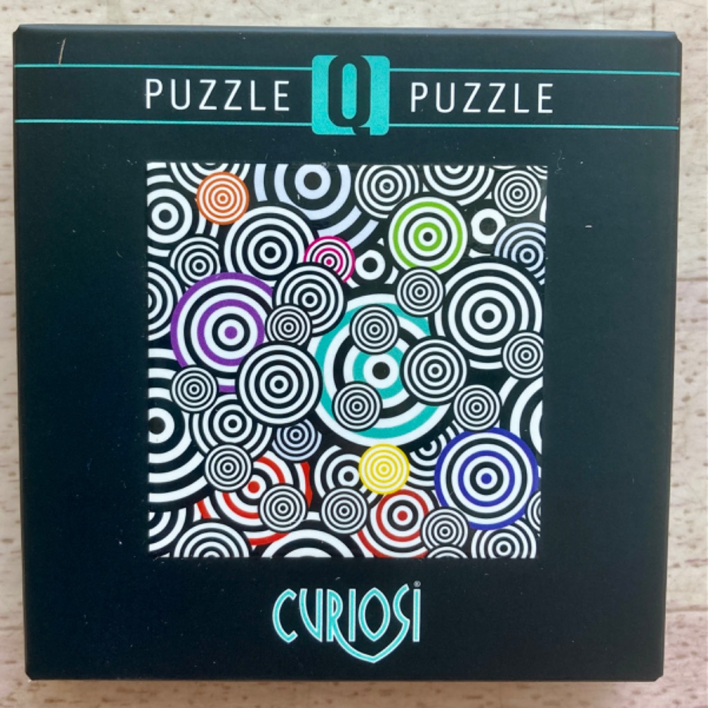 An abstract pattern of overlapping black and white concentric circles with pops of bright colors.