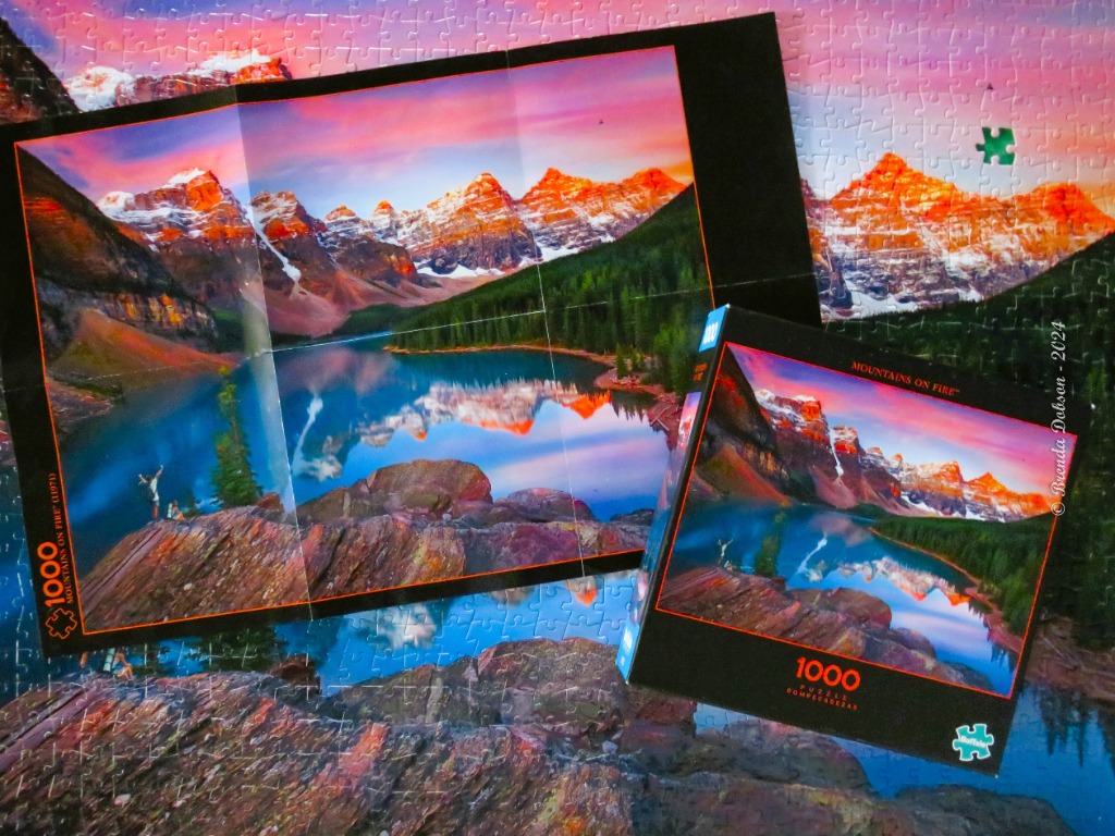 A panoramic landscape of Moraine Lake and the Valley of the Ten Peaks at sunrise with vibrant red and orange mountain glow.