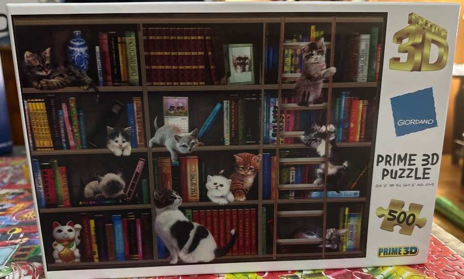 A collection of kittens playing on and around a multi-tiered wooden bookshelf filled with various colorful books.