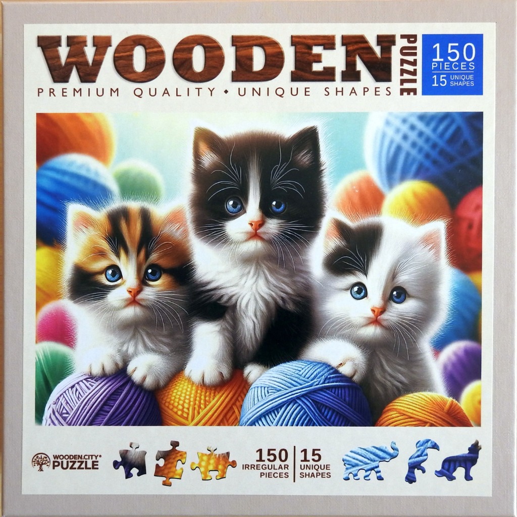 Three fluffy kittens with bright blue eyes sitting among colorful yarn balls.
