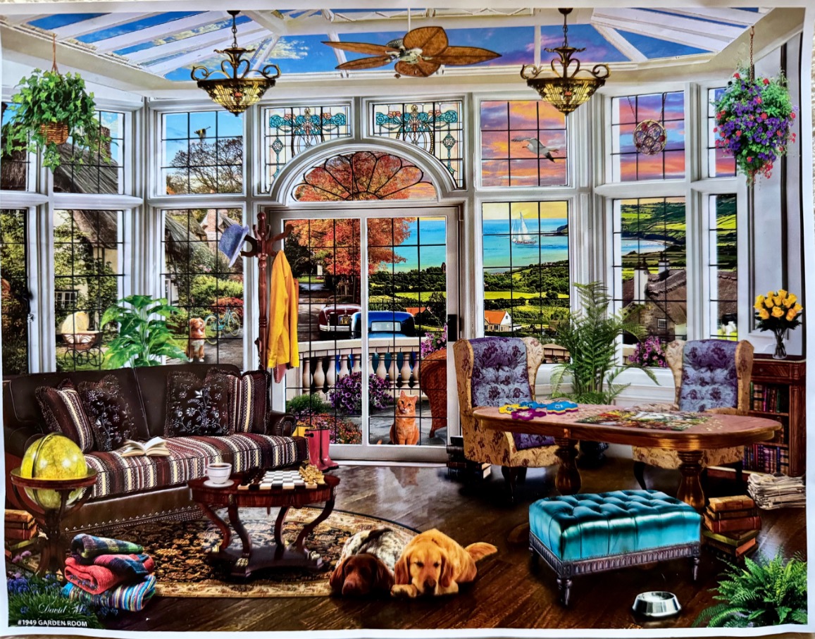 A cozy, sunlit garden room with large windows, two dogs resting on the floor, and a view of the sea.
