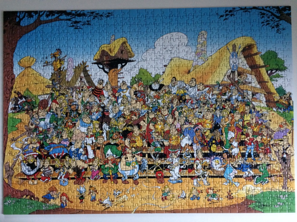 A crowded, colourful cartoon illustration featuring dozens of Asterix characters in a village setting.