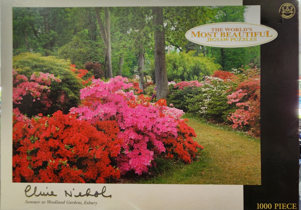 A lush, vibrant garden path surrounded by blooming azalea bushes in shades of red and pink.