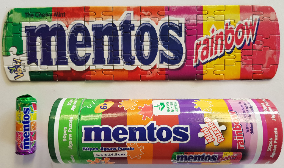 A rectangular sign for Mentos Rainbow candy with a colorful striped background and bold blue text.
