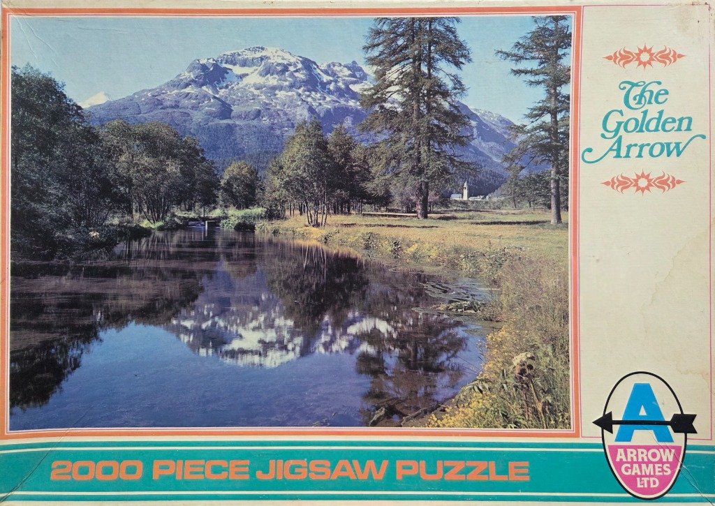 A peaceful alpine landscape with a mountain reflecting in a calm river, surrounded by trees and a meadow.