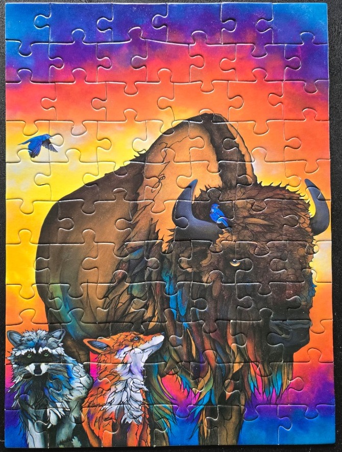 A bison, a fox, and a raccoon stand before a sunset sky with blue birds.
