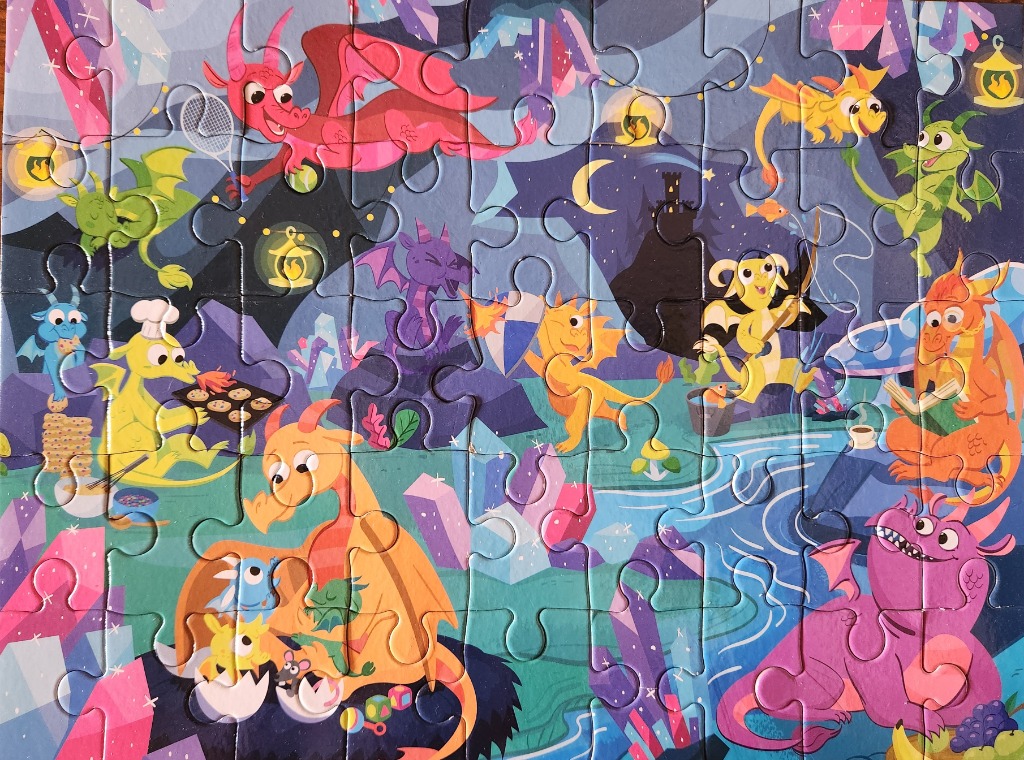 A cartoon illustration of many colorful, friendly dragons in a whimsical night landscape.