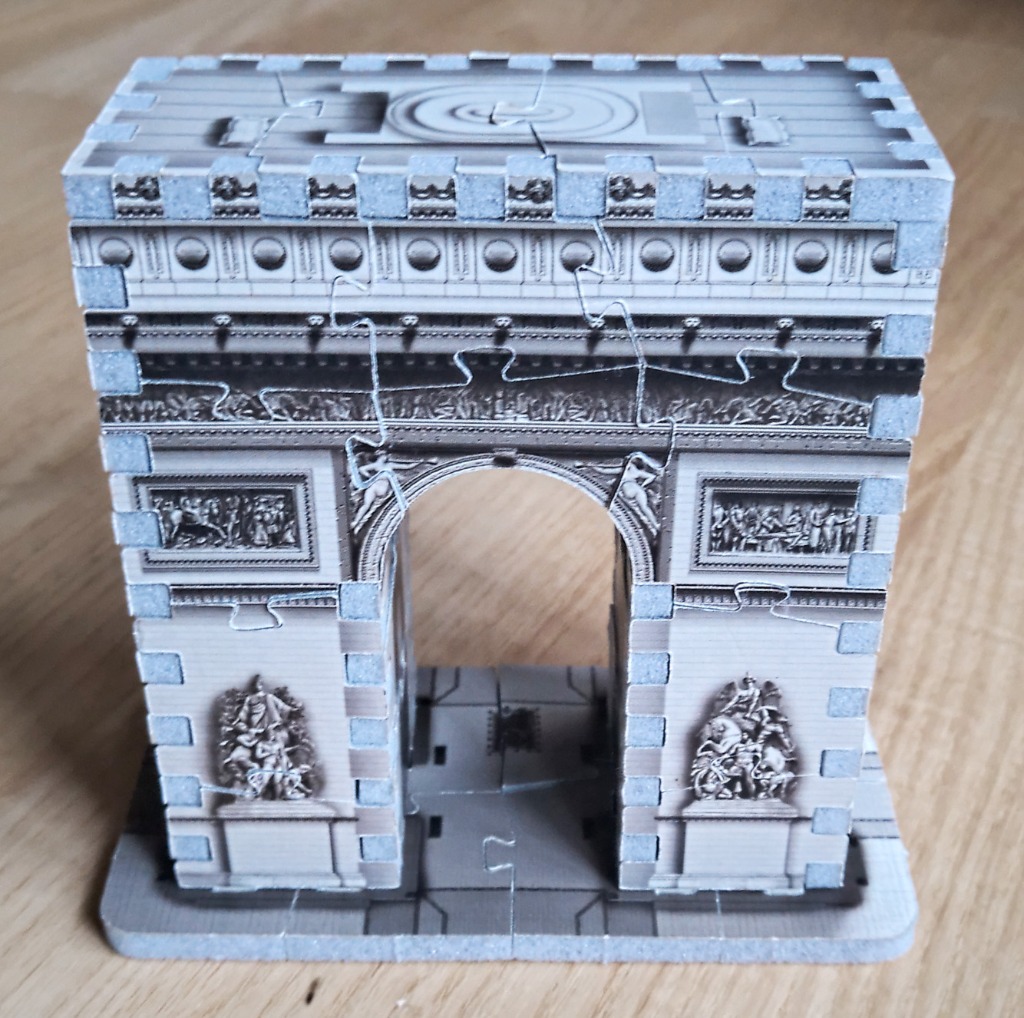 A small 3D model of the Arc de Triomphe in black and white.