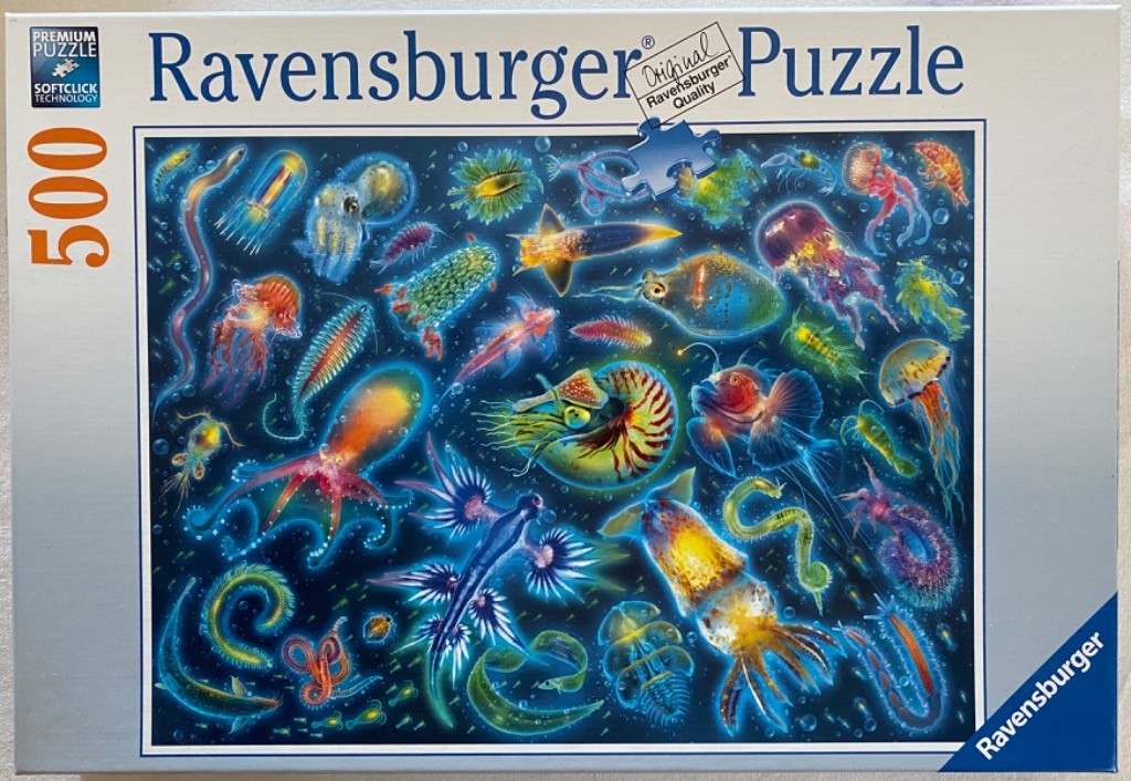 Collage of various colorful, glowing deep-sea creatures against a dark blue background.