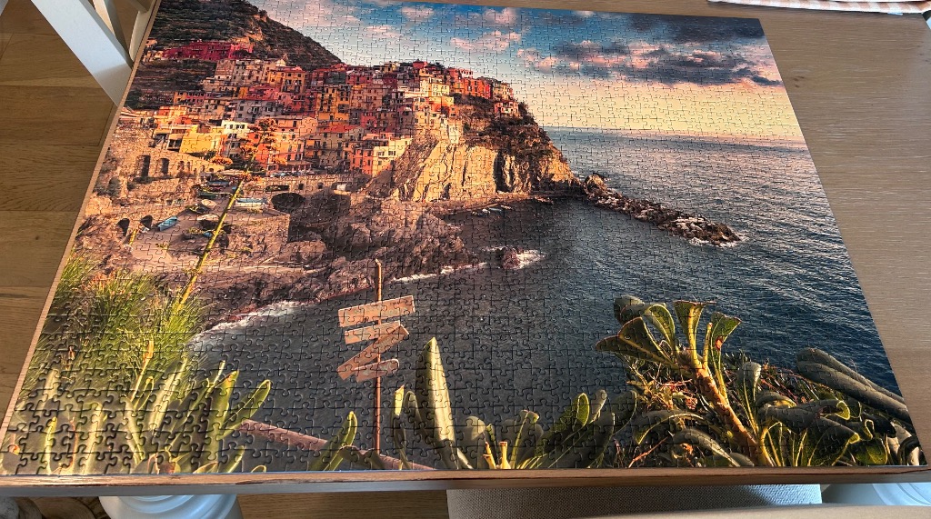 A panoramic view of the colorful cliffside village of Manarola, Italy, at sunset.