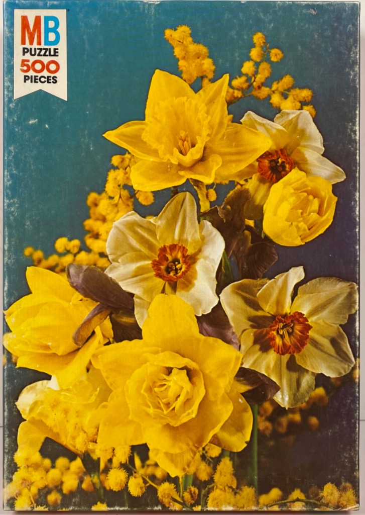 A close-up photograph of a vibrant bouquet of yellow daffodils and mimosa blossoms against a dark blue background.