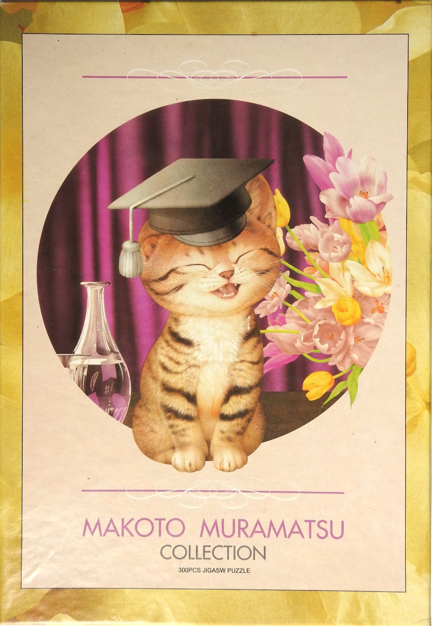 A joyful tabby kitten wearing a graduation cap, positioned in a circular frame with flowers and a glass carafe.