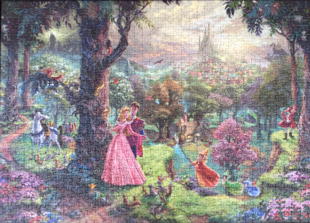 Sleeping Beauty and Prince Phillip in a lush, magical forest scene with a castle in the distance.