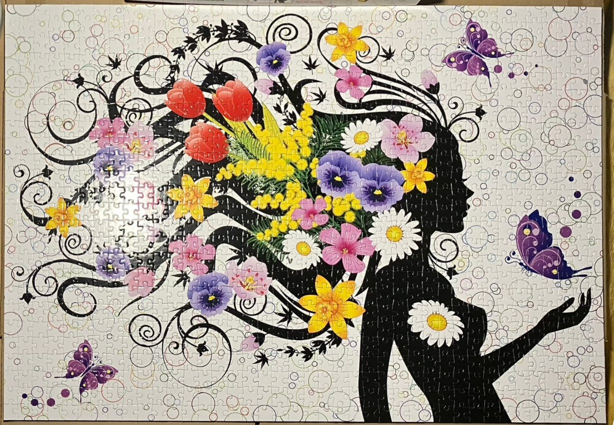 A silhouette of a woman with long, swirling hair made of colorful flowers and black filigree.
