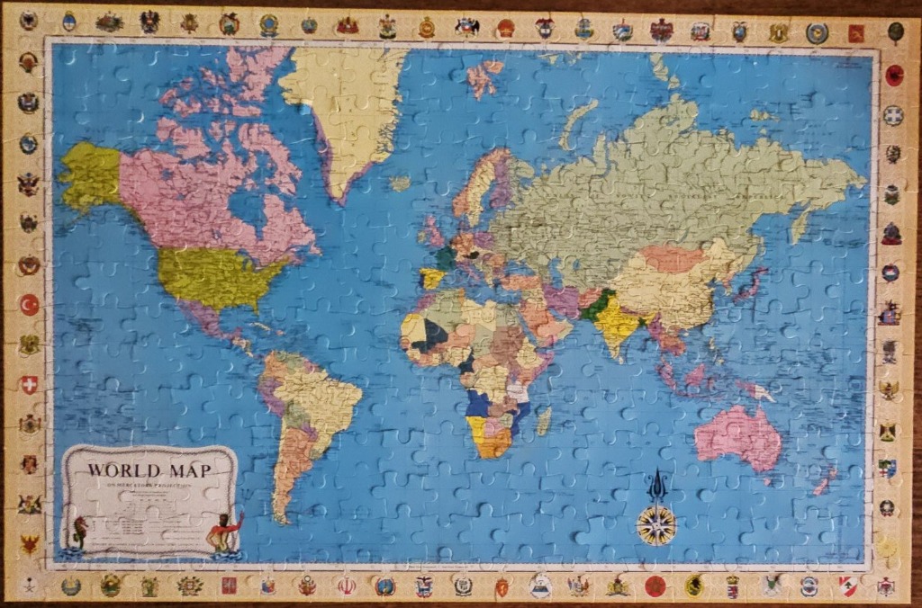 A vintage-style Mercator world map surrounded by a border of national flags and emblems.