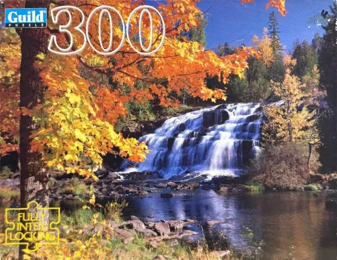 A cascading waterfall surrounded by vibrant autumn trees with bright orange and yellow foliage.