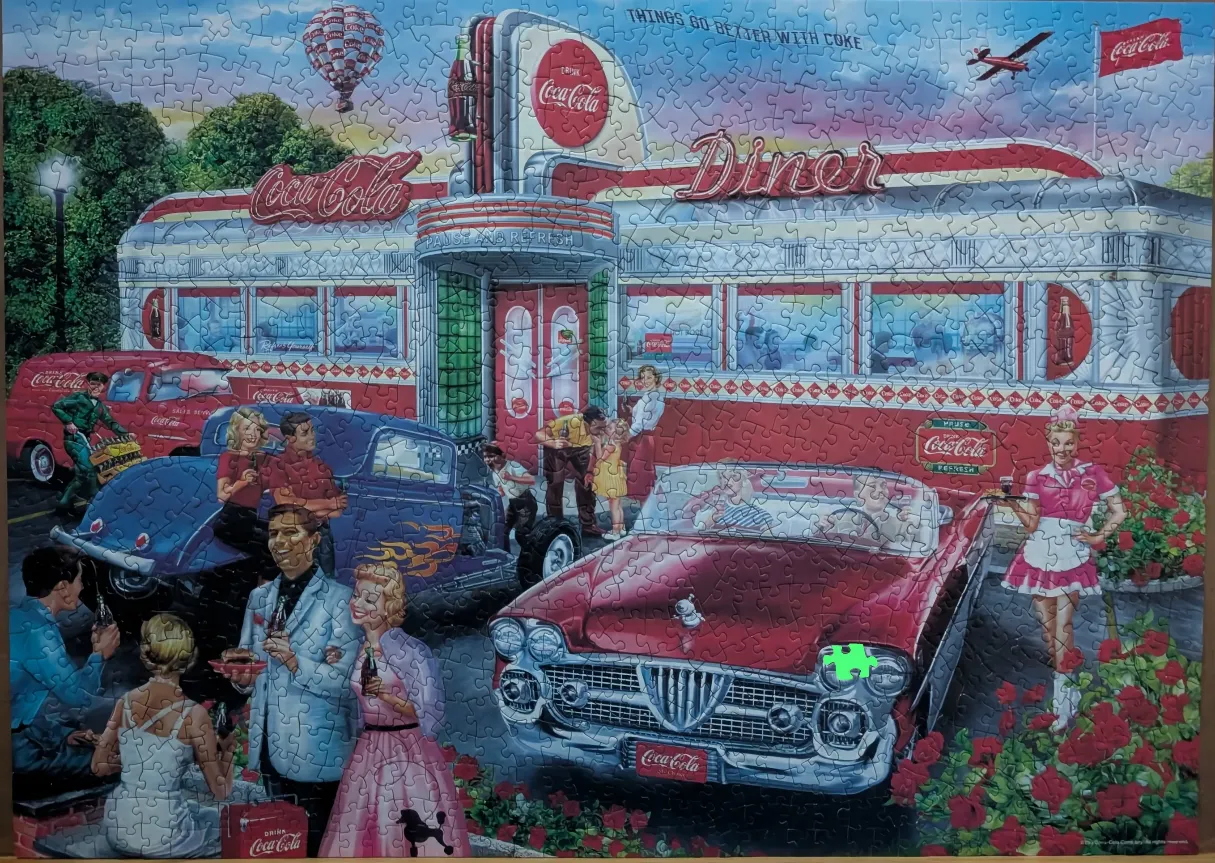 A vibrant 1950s-style illustration of a red and white retro diner with classic cars and people in period attire.