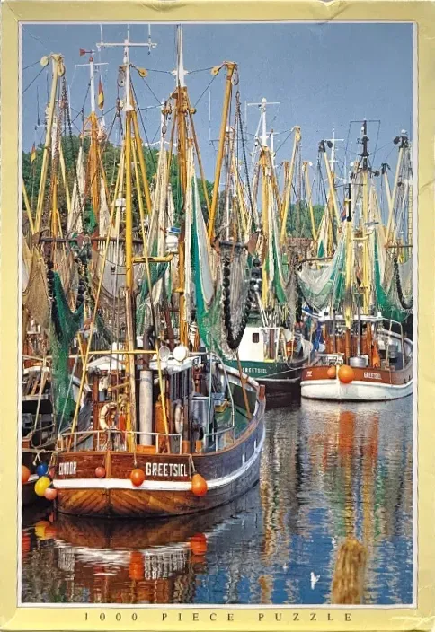 A fleet of wooden fishing trawlers moored in a harbor, with tall yellow masts and green nets.