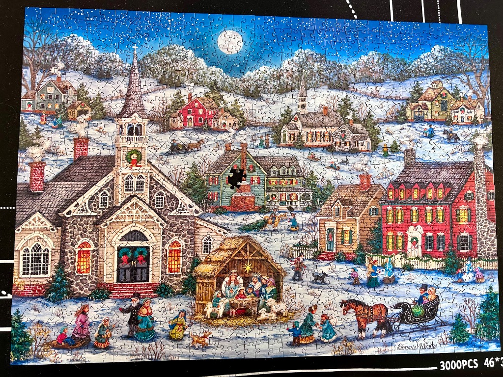A folk art illustration of a snowy winter village at night with a central church and a nativity scene.
