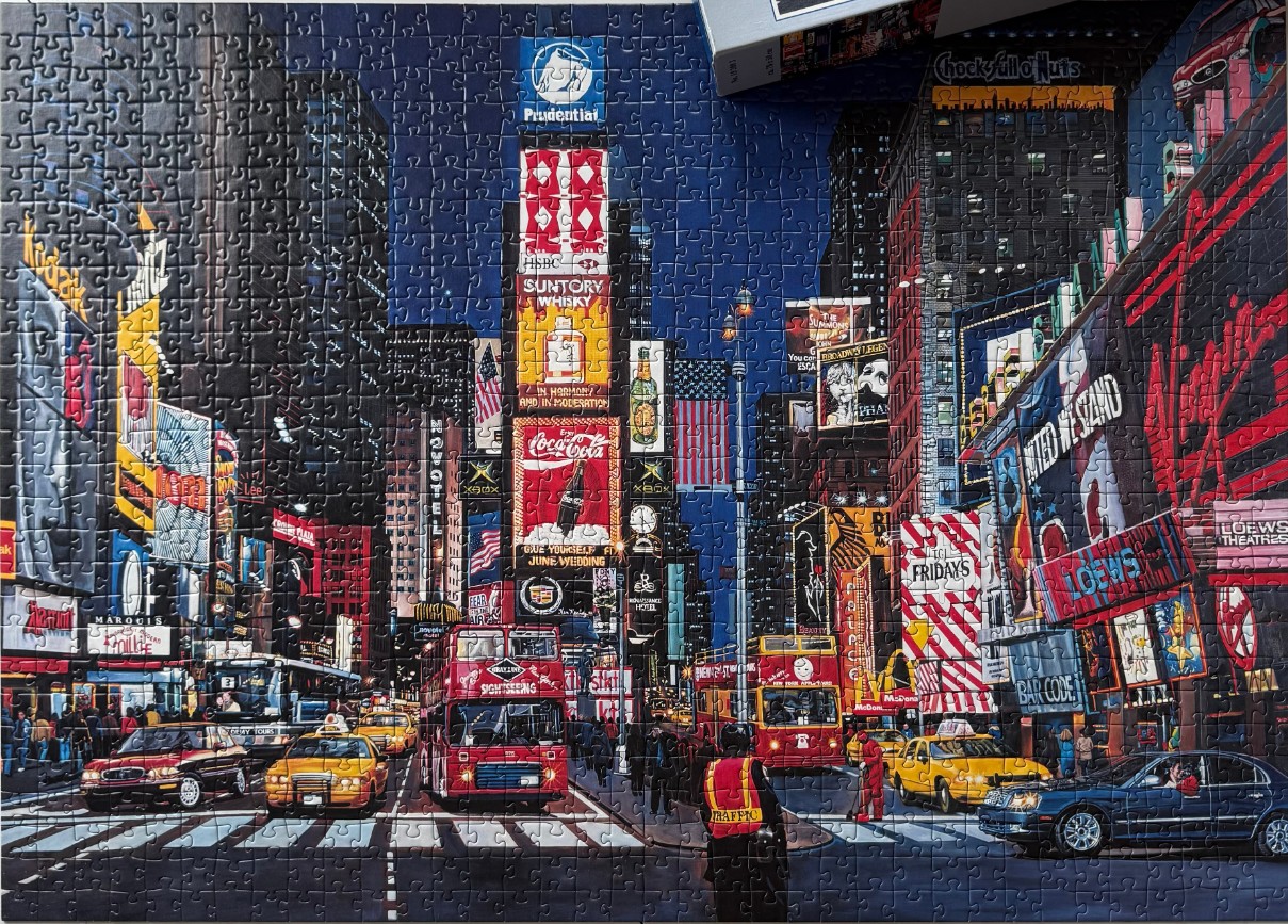 A nighttime street-level view of Times Square in New York City with bright neon signs and busy traffic.