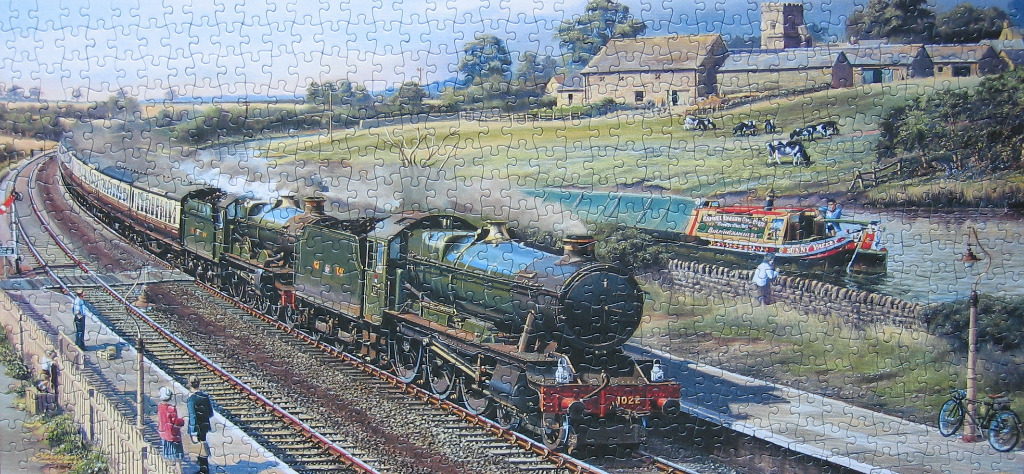 A countryside scene featuring a steam train passing a narrowboat on a canal.