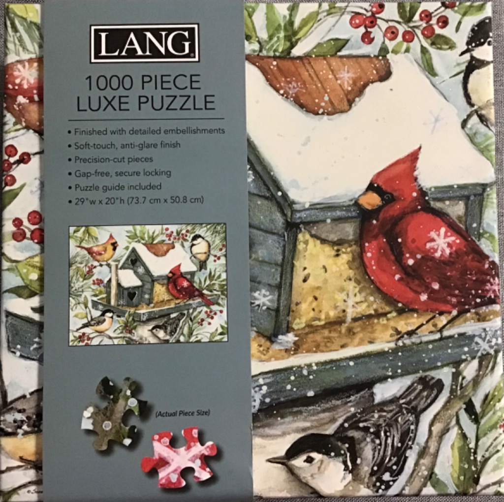 Watercolor illustration of a snowy bird feeder surrounded by a male cardinal, a chickadee, and a nuthatch.