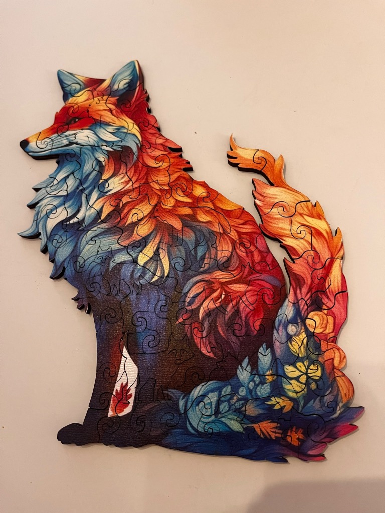 An artistic illustration of a fox with abstract, fire-like multi-coloured fur on a plain background.