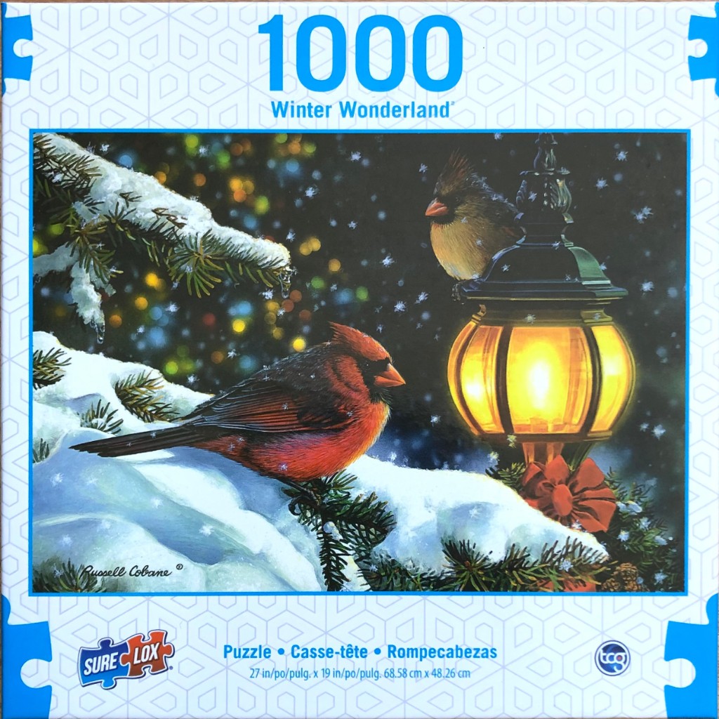 Two cardinals resting on a snowy evergreen branch near a glowing vintage lantern at night.