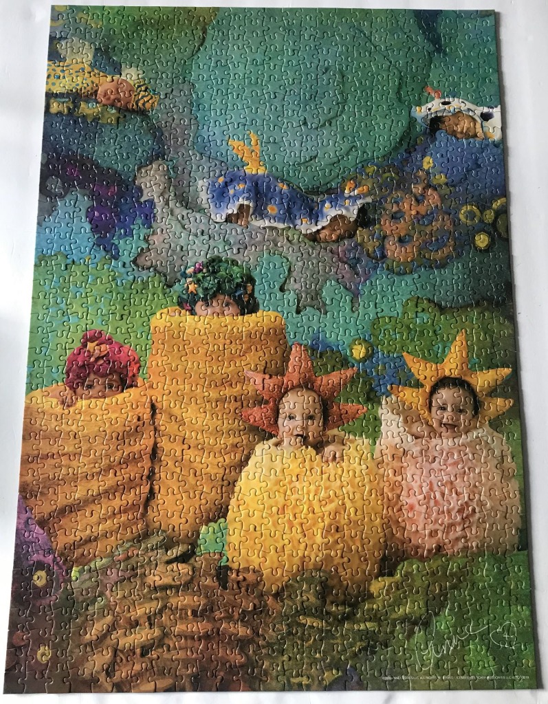Four babies in colorful, whimsical costumes against an abstract, dreamlike green and blue background.