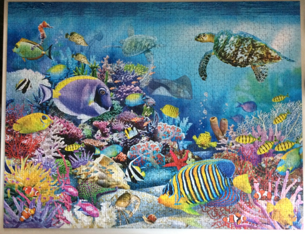Vibrant coral reef scene filled with various tropical fish, a sea turtle, and a stingray.