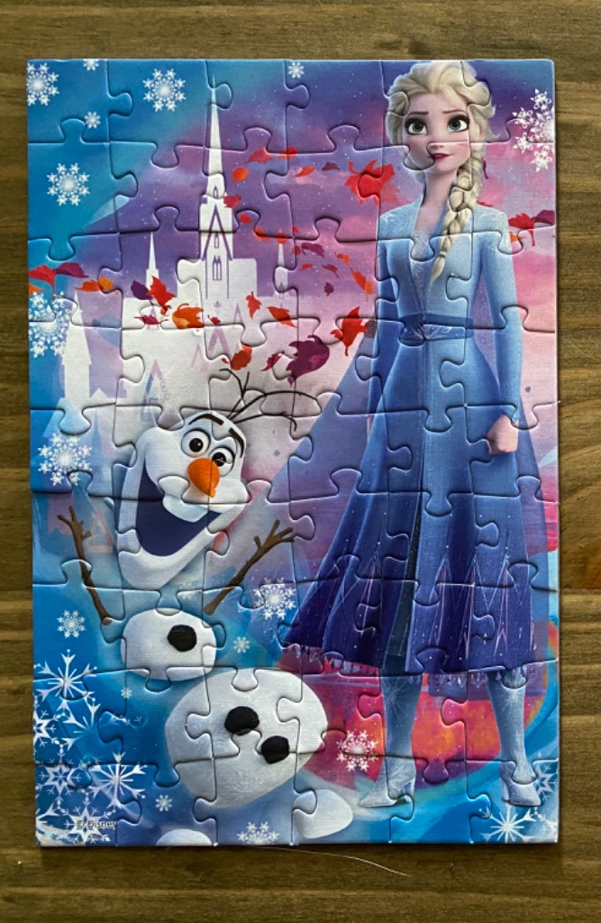 Elsa and Olaf from Frozen against a background of a crystalline palace and autumn leaves.