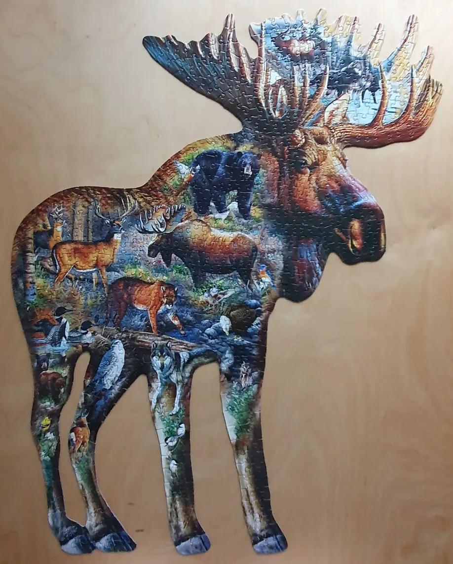 A silhouette shaped like a moose, filled with a detailed illustration of North American wildlife.