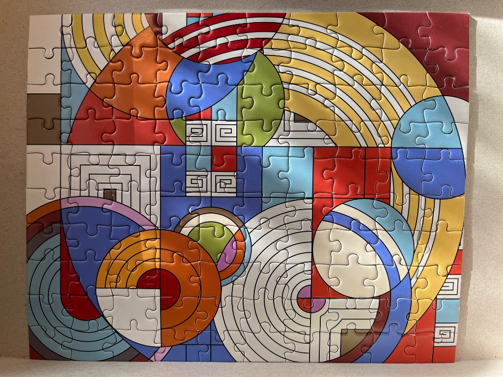 Abstract geometric composition featuring vibrant circles, concentric arcs, and square patterns in red, yellow, and blue.