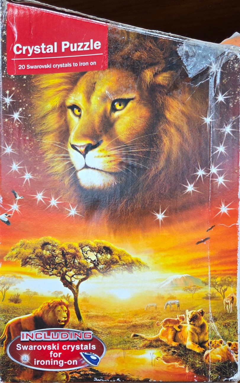 A majestic lion face in a starry sky above an African savannah landscape with lions, zebras, and giraffes at sunset.