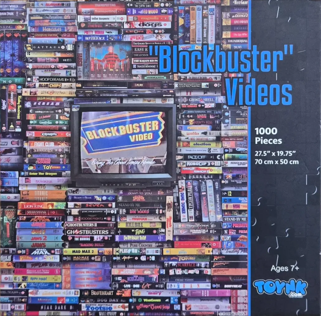 A collage of classic VHS movie tapes surrounding a television screen displaying a Blockbuster Video sign.