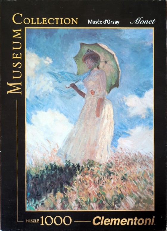 A 1000-piece jigsaw puzzle box featuring an Impressionist painting of a woman with a parasol standing in a field.