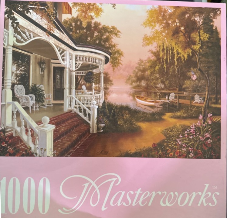 A peaceful lakeside scene featuring a Victorian house porch at sunset with a boat docked nearby.