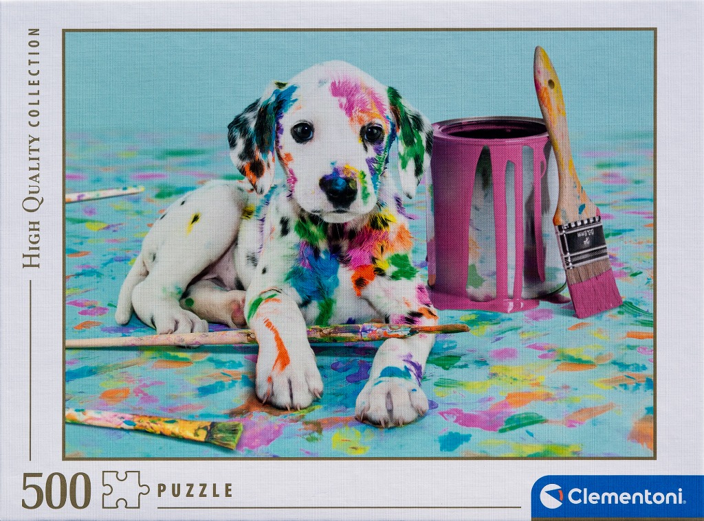 A puppy covered in colorful paint splotches sitting next to a paint can and brushes.