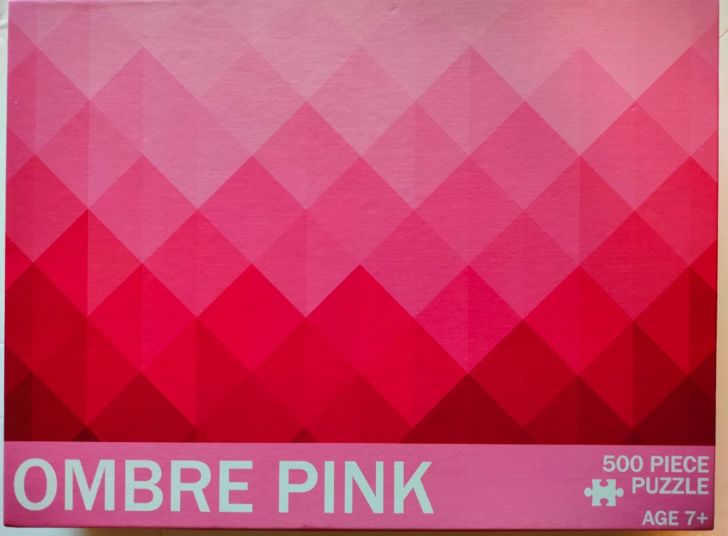 Abstract geometric pattern of triangles in varying shades of pink, transitioning from light at the top to dark at the base.